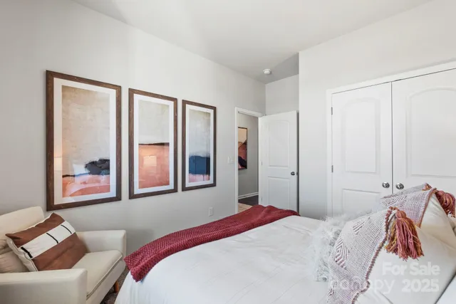 a bedroom with a bed and a painting on the wall