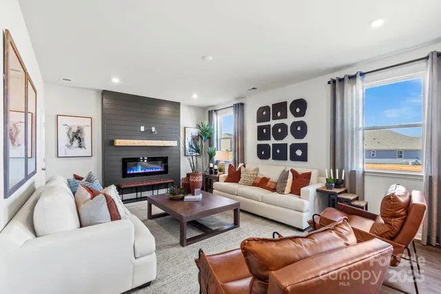 a living room with furniture a fireplace and a large window