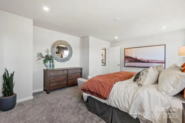 a bedroom with a bed a mirror and a potted plant