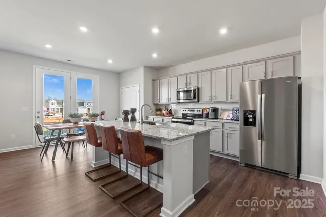a kitchen with a sink a counter top space stainless steel appliances and cabinets