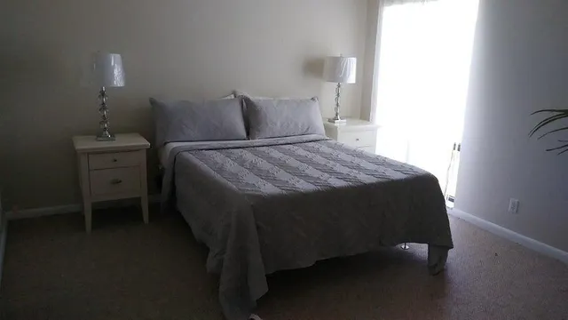 a bedroom with a bed and a lamp on the dresser