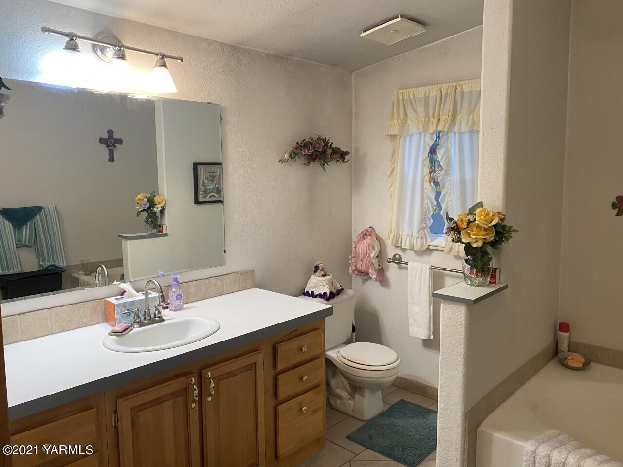 2810 South Wiley Road Yakima, WA 98903 - Photo 8 of 17 a bathroom with a sink a toilet and a mirror
