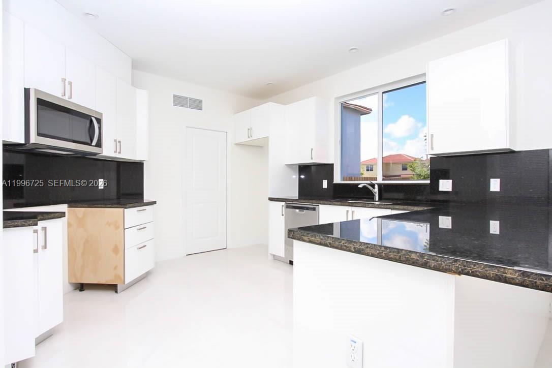 15631 Southwest 11th Terrace Miami, FL 33194 - Photo 23 of 43 a kitchen with stainless steel appliances granite countertop a refrigerator a stove and a sink with granite countertops