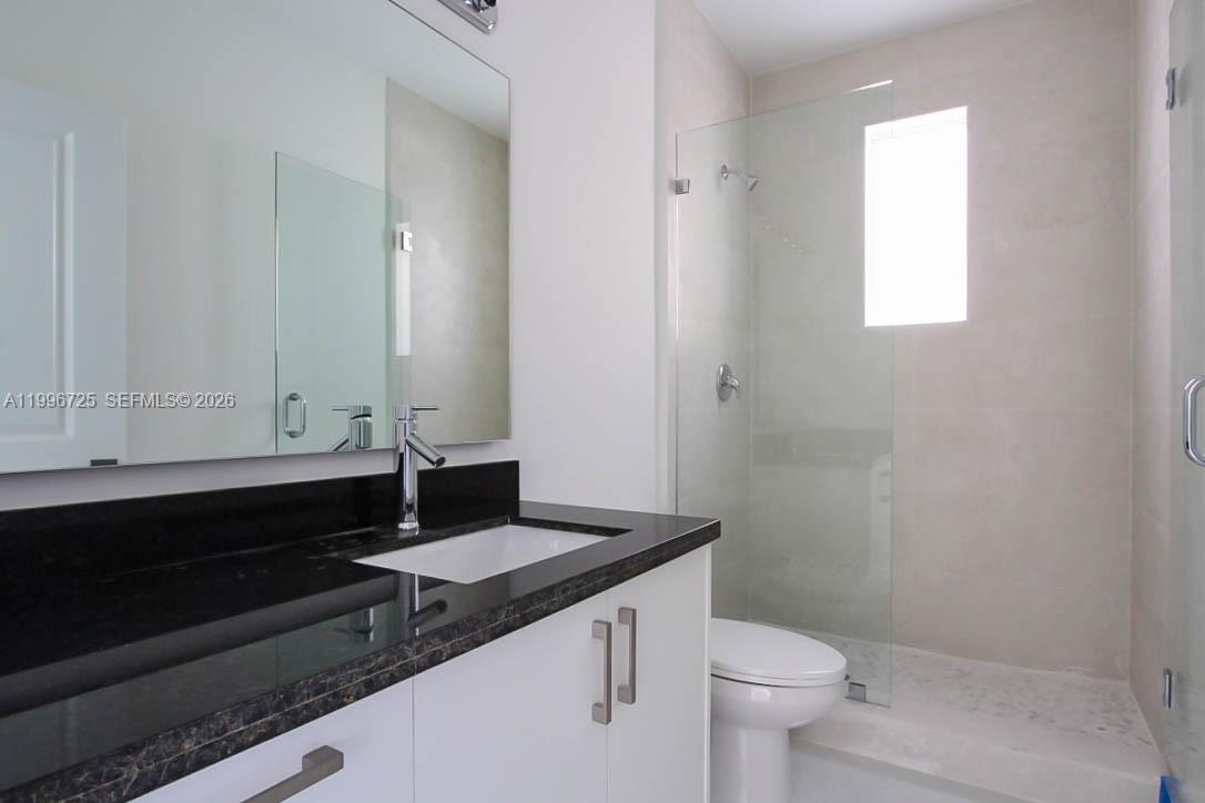 15631 Southwest 11th Terrace Miami, FL 33194 - Photo 31 of 43 a bathroom with a granite countertop sink toilet and mirror