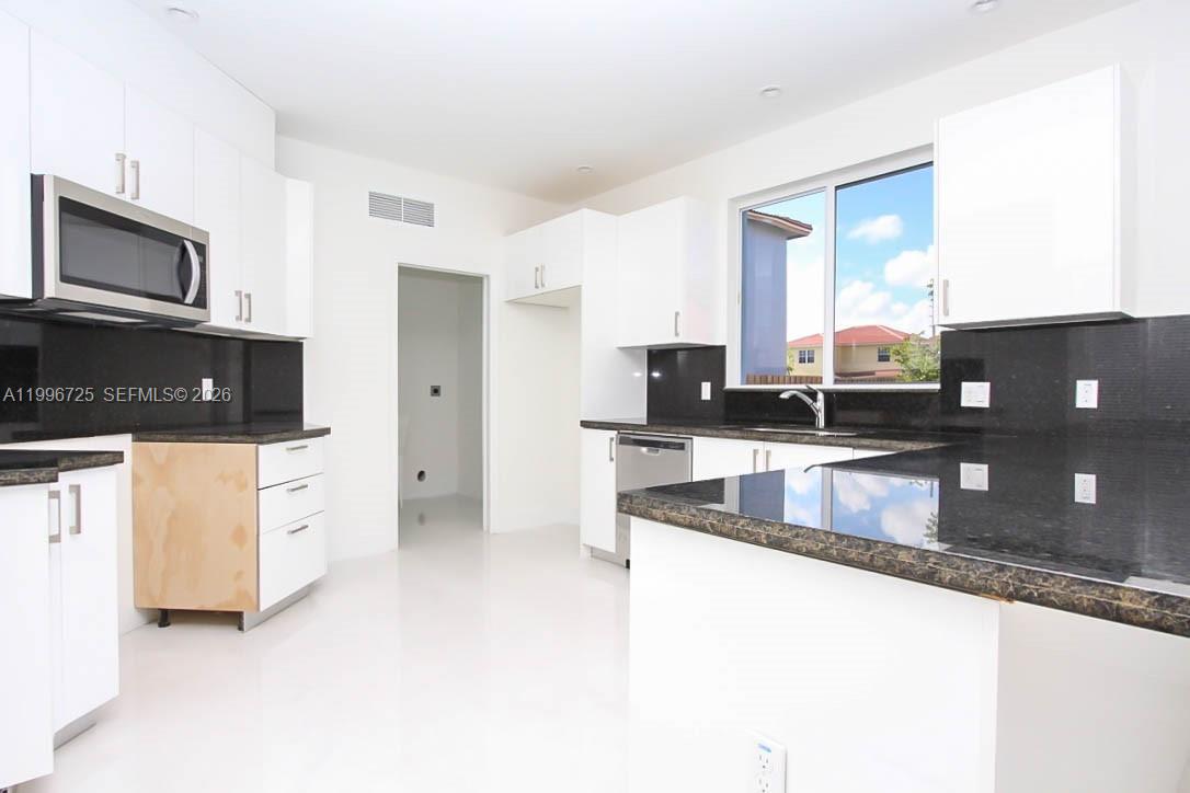 15631 Southwest 11th Terrace Miami, FL 33194 - Photo 9 of 43 a kitchen with stainless steel appliances granite countertop a refrigerator a stove and a sink