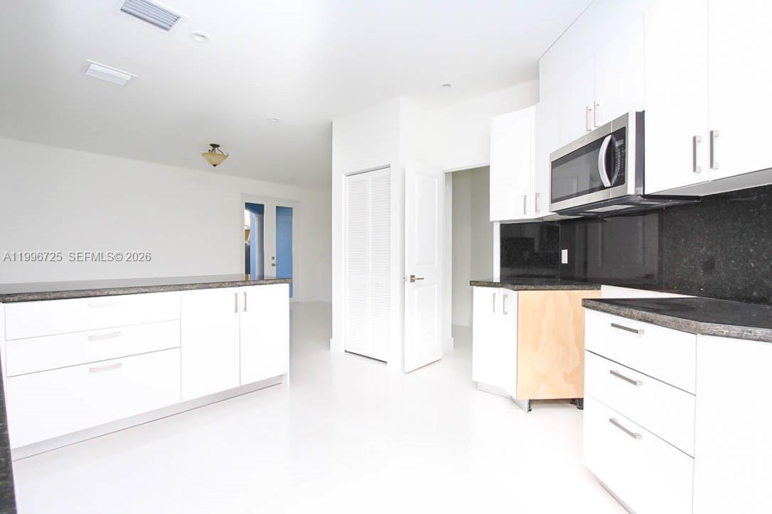 15631 Southwest 11th Terrace Miami, FL 33194 - Photo 10 of 43 a kitchen with stainless steel appliances kitchen island granite countertop a refrigerator a stove and white cabinets