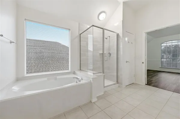 a spacious bathroom with a bathtub and a shower