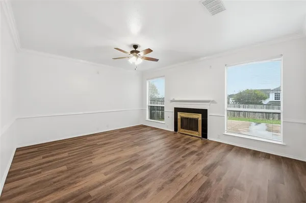 a view of empty room with wooden floor and fireplace