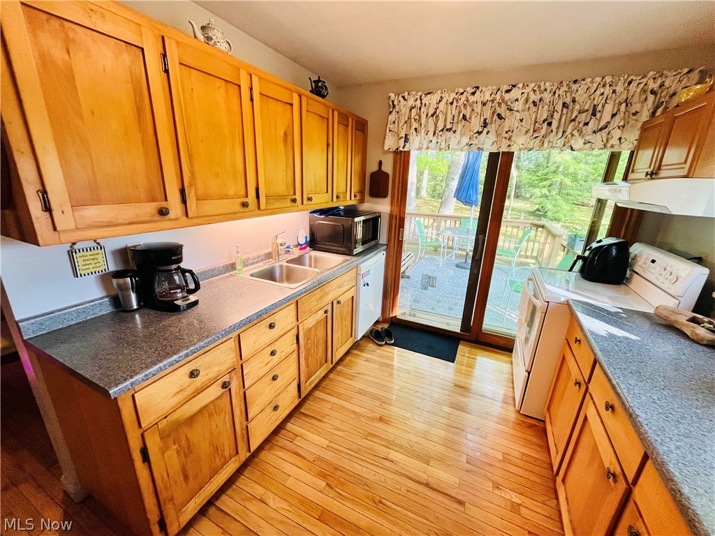 7220 Doty Road Madison, OH 44057 - Photo 32 of 50 Kitchen featuring sink, washer / clothes dryer, white appliances, and light wood-type flooring