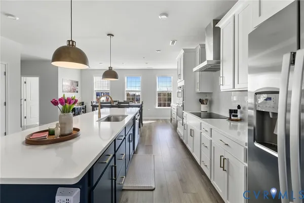 a kitchen with stainless steel appliances a dining table chairs stove and cabinets
