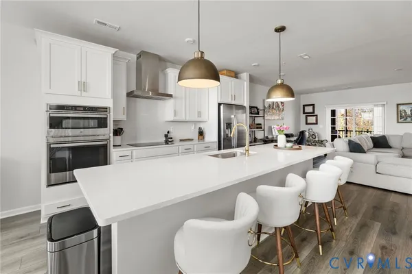 a kitchen with stainless steel appliances kitchen island granite countertop a sink a stove and white cabinets