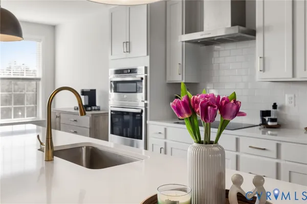a kitchen with stainless steel appliances kitchen island granite countertop a sink and white cabinets