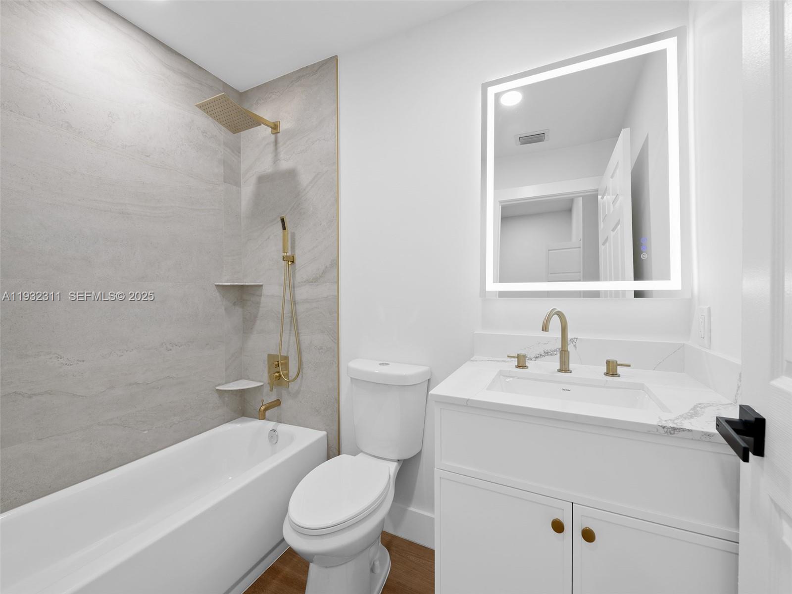 2014 Northwest 52nd Street Boca Raton, FL 33496 - Photo 16 of 26 a bathroom with a sink a toilet and a mirror