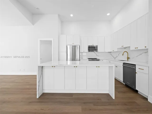 a kitchen with a sink cabinets and wooden floor