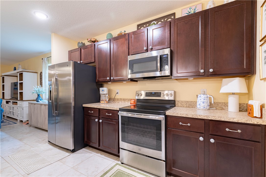 898 Lorca Avenue Sebastian, FL 32958 - Photo 17 of 36 a kitchen with granite countertop wooden cabinets stainless steel appliances and a counter space