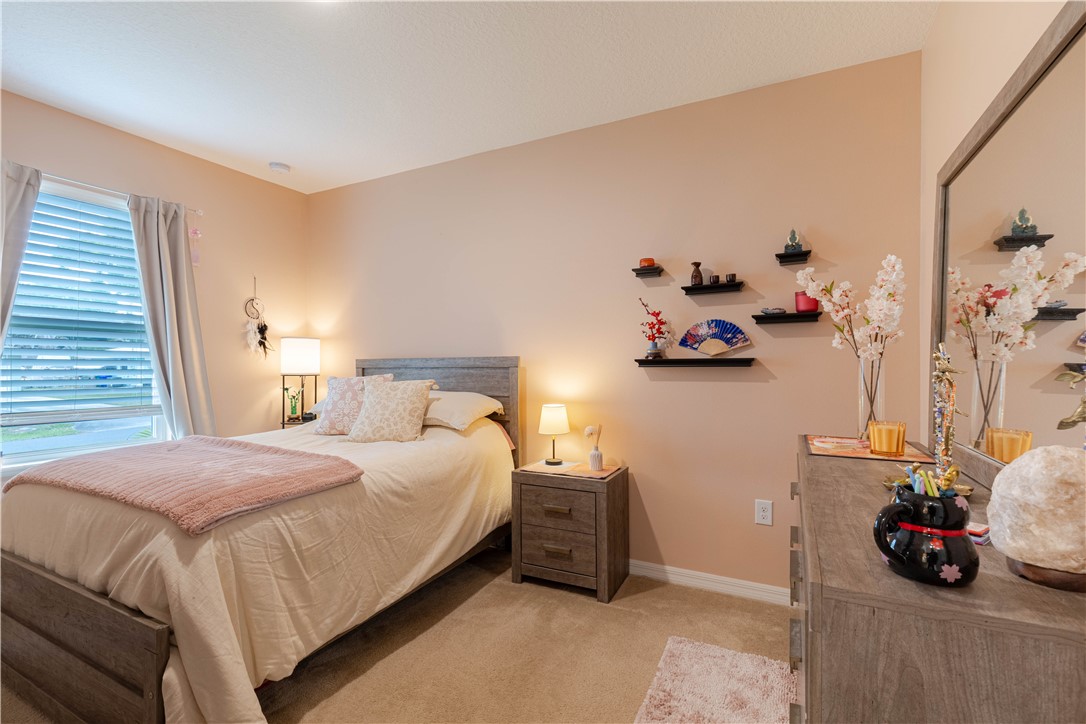898 Lorca Avenue Sebastian, FL 32958 - Photo 30 of 36 a bedroom with a bed and a couch