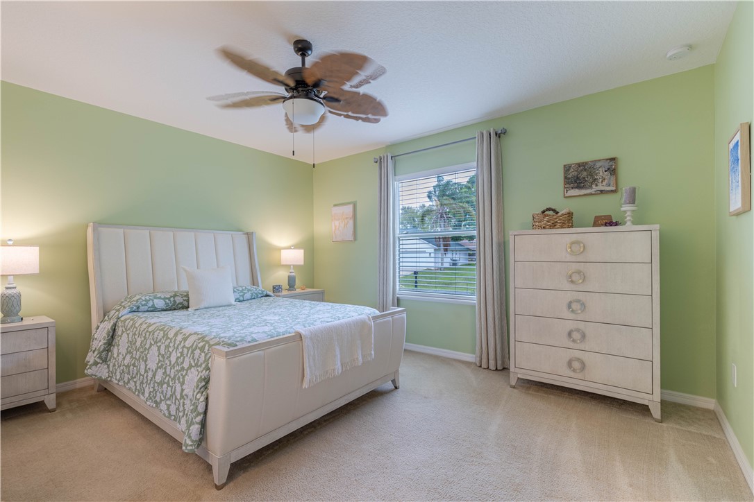 898 Lorca Avenue Sebastian, FL 32958 - Photo 31 of 36 a bedroom with a bed and a chandelier