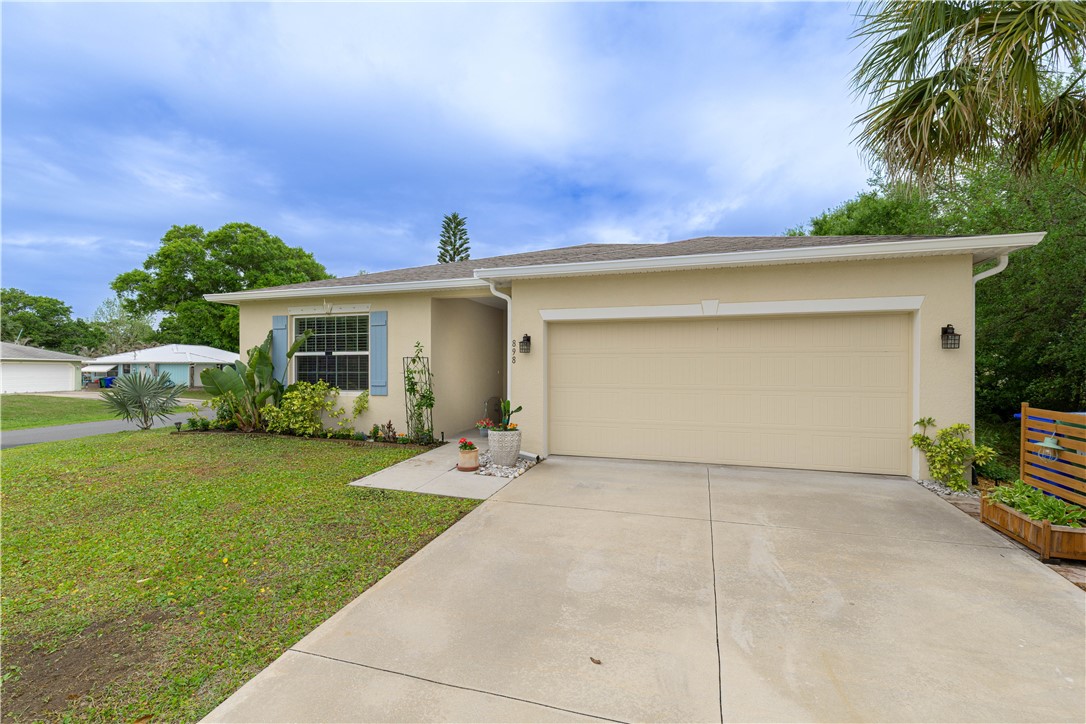 898 Lorca Avenue Sebastian, FL 32958 - Photo 8 of 36 a front view of a house with a yard and garage