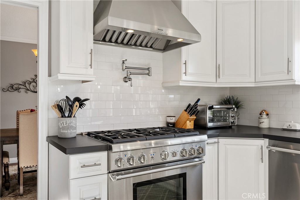 31041 Augusta Drive Laguna Niguel, CA 92677 - Photo 9 of 35 a kitchen with stainless steel appliances granite countertop a stove and white cabinets