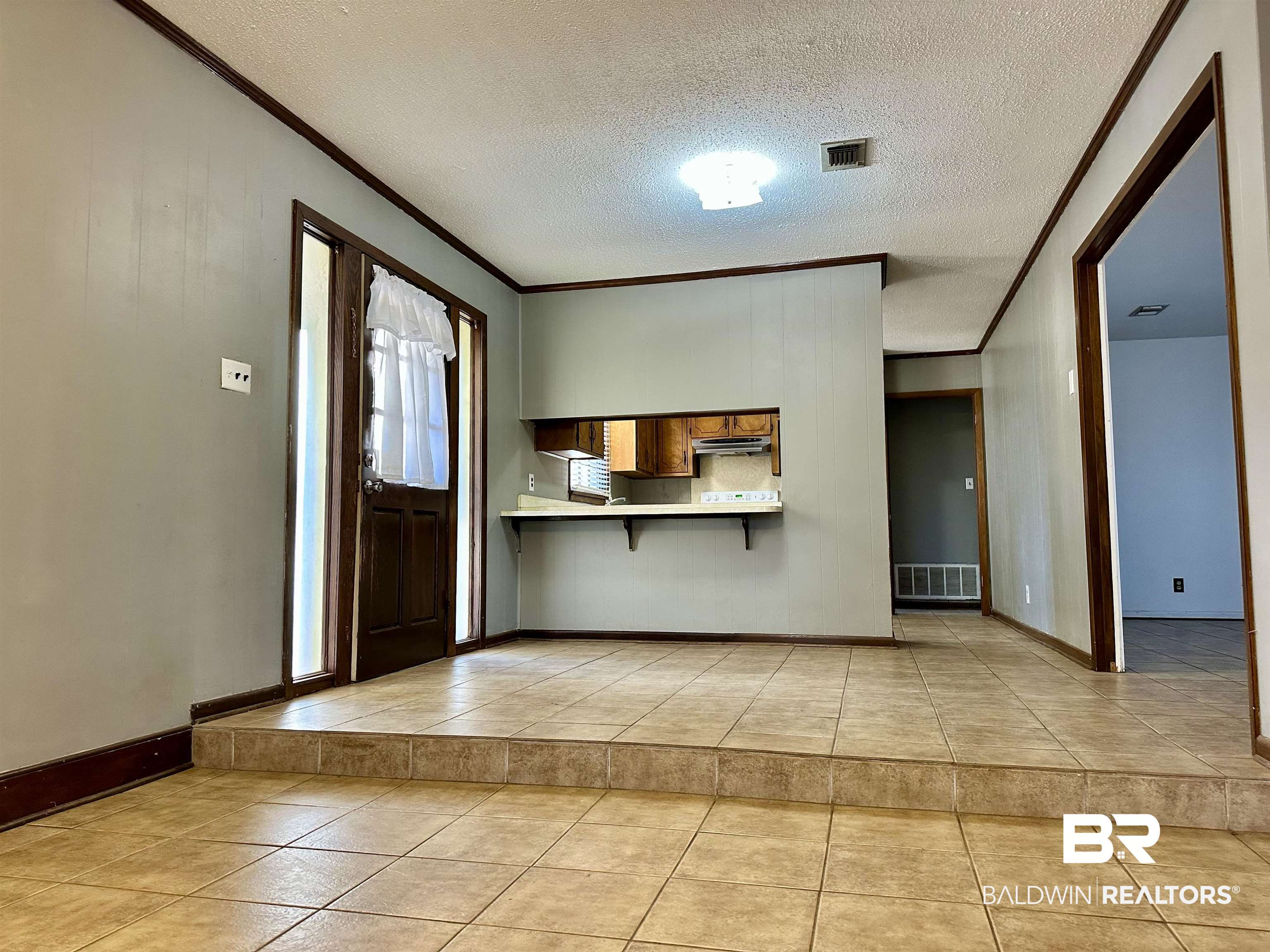 2664 Sowell Road Brewton, AL 36426 - Photo 3 of 12 Entrance foyer with a textured ceiling, light tile patterned floors, and ornamental molding