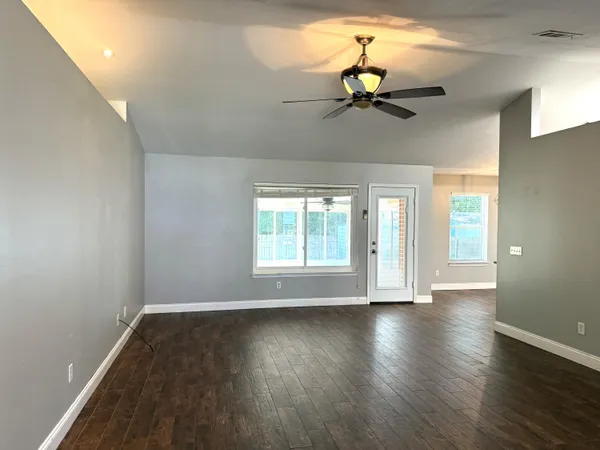 a view of a livingroom with a chandelier fan and a window