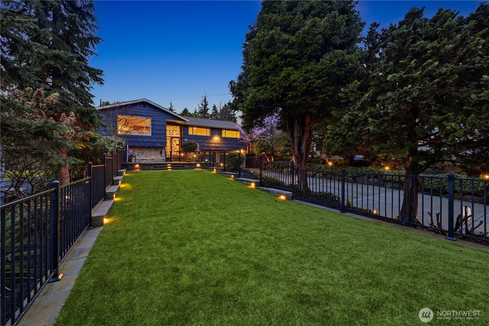 a view of a yard with wooden fence and a large tree