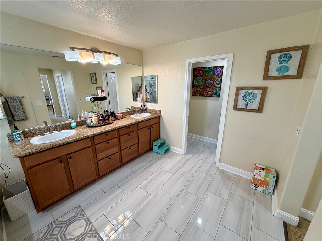13538 Applegate Court Rancho Cucamonga, CA 91739 - Photo 16 of 30 a bathroom with a double vanity sink and a mirror