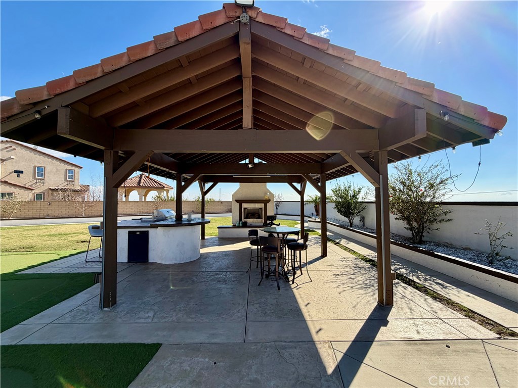 13538 Applegate Court Rancho Cucamonga, CA 91739 - Photo 21 of 30 a view of a patio with table and chairs under an umbrella with a barbeque