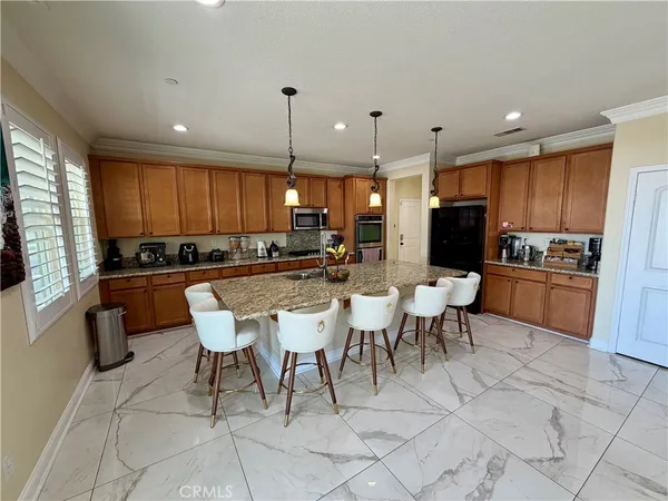a kitchen with a dining table chairs and refrigerator