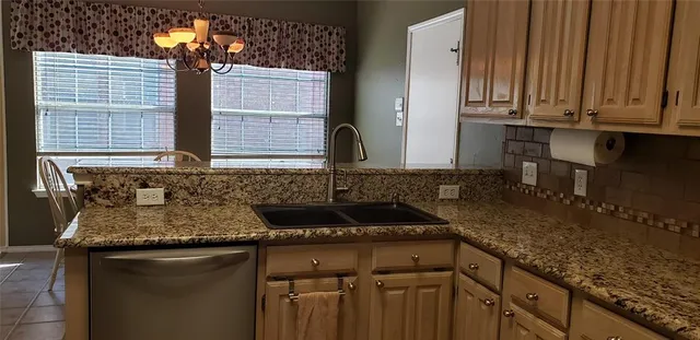 a kitchen with granite countertop a sink a stove and cabinets
