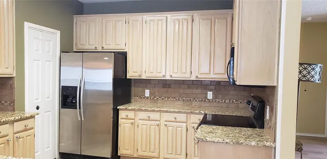 a kitchen with appliances cabinets and a counter top space