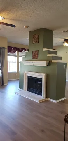 a view of empty room with wooden floor and fireplace