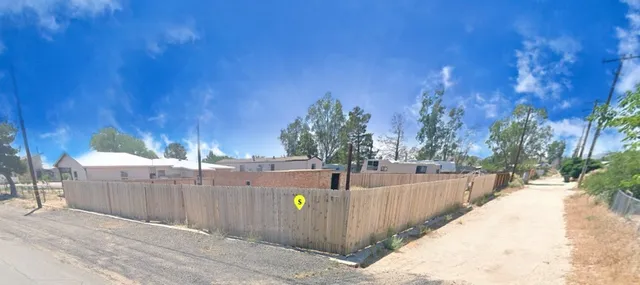 a view of a backyard with wooden fence