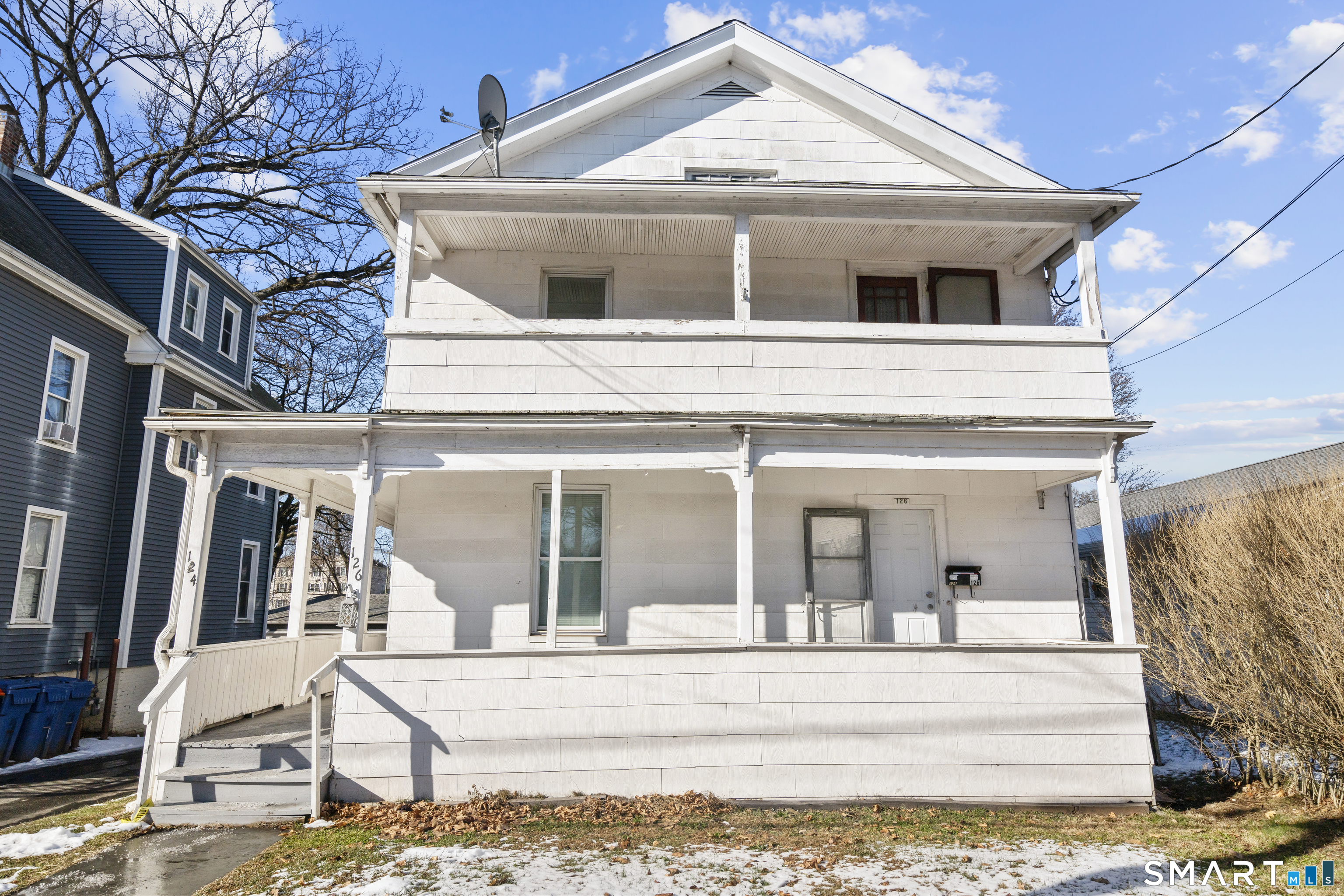 a view of a white house with large windows and couches