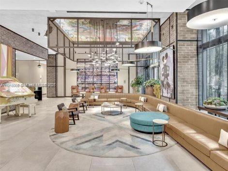 121 Northeast 34th Street, Unit 2811 Miami, FL 33137 - Photo 25 of 35 a living room with couches and a dining table with large windows