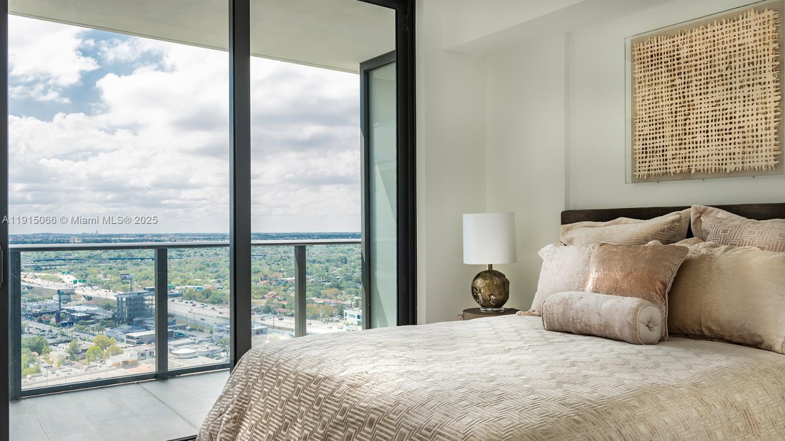 121 Northeast 34th Street, Unit 2811 Miami, FL 33137 - Photo 3 of 35 a bedroom with a large window and a bed