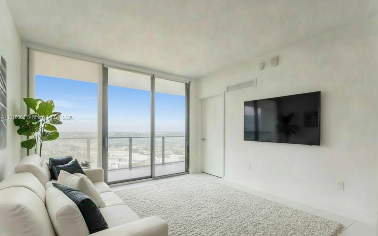 121 Northeast 34th Street, Unit 2811 Miami, FL 33137 - Photo 4 of 35 a living room with furniture and a flat screen tv