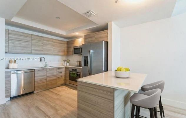 121 Northeast 34th Street, Unit 2811 Miami, FL 33137 - Photo 5 of 35 a kitchen with a sink cabinets and stainless steel appliances