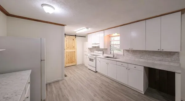 a kitchen with granite countertop white cabinets and white appliances
