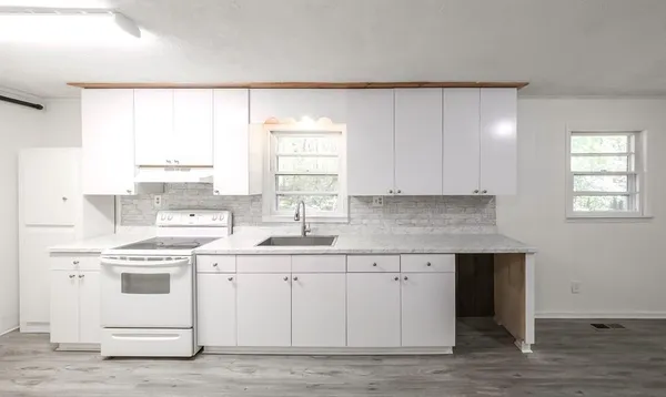 a kitchen with a stove a sink and a window