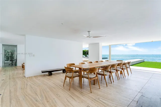 a view of a backyard with lawn chairs potted plants and swimming pool