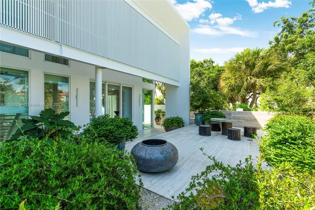 a front view of a house with a yard and potted plants