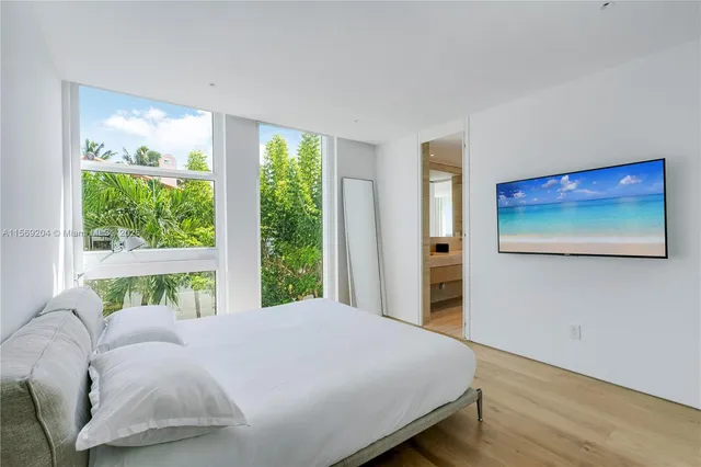 a living room with furniture a flat screen tv and a large window