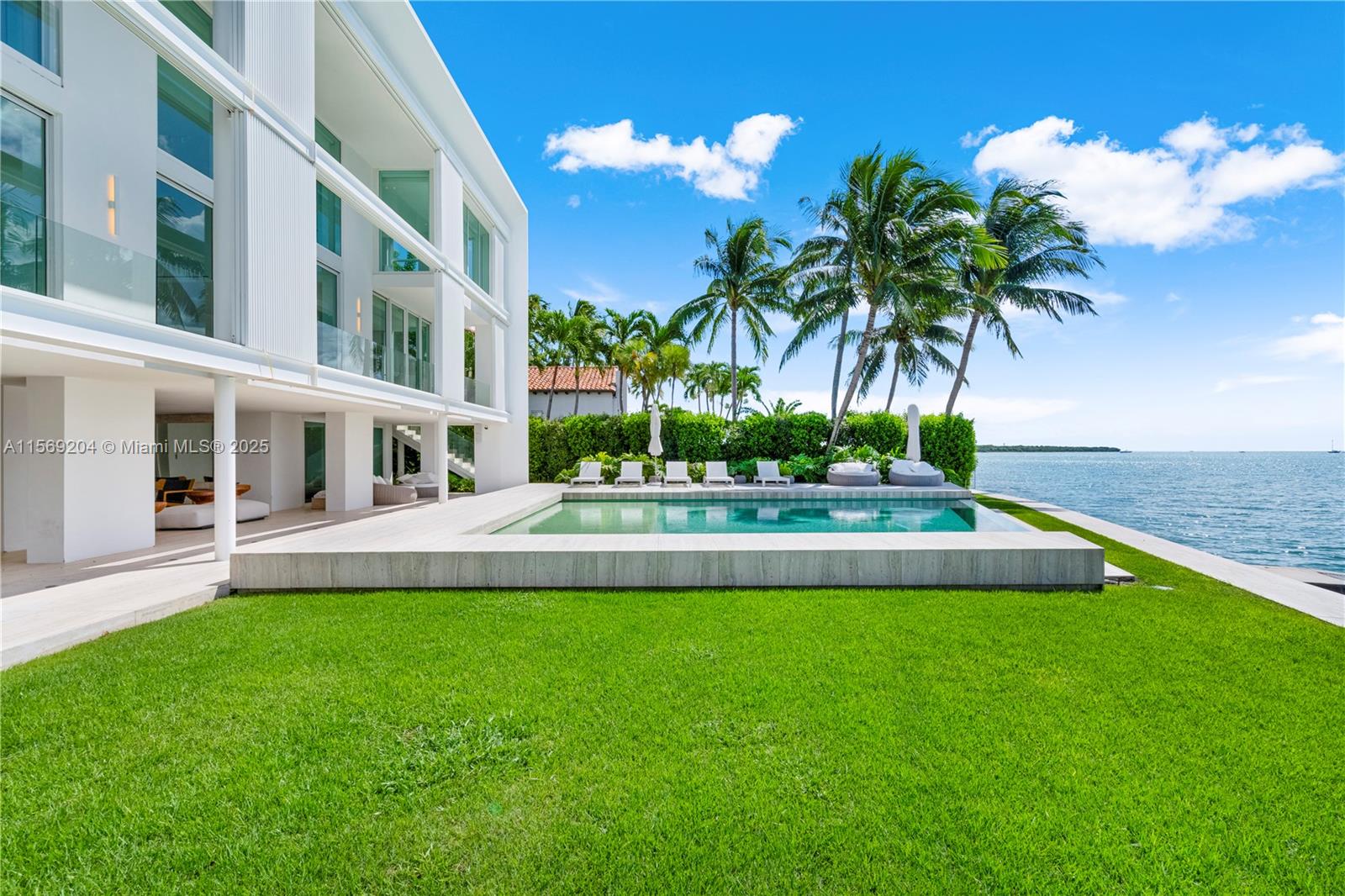 440 South Mashta Drive Key Biscayne, FL 33149 - Photo 79 of 100 a view of a house with a swimming pool and a yard
