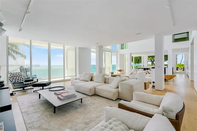 a living room with furniture a flat screen tv and floor to ceiling window