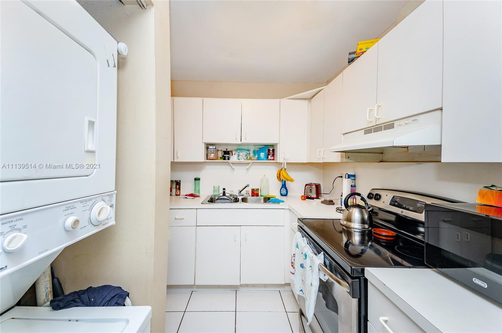 15280 Southwest 80th Street, Unit 11 Miami, FL 33193 - Photo 3 of 13 a kitchen with a sink a stove and cabinets