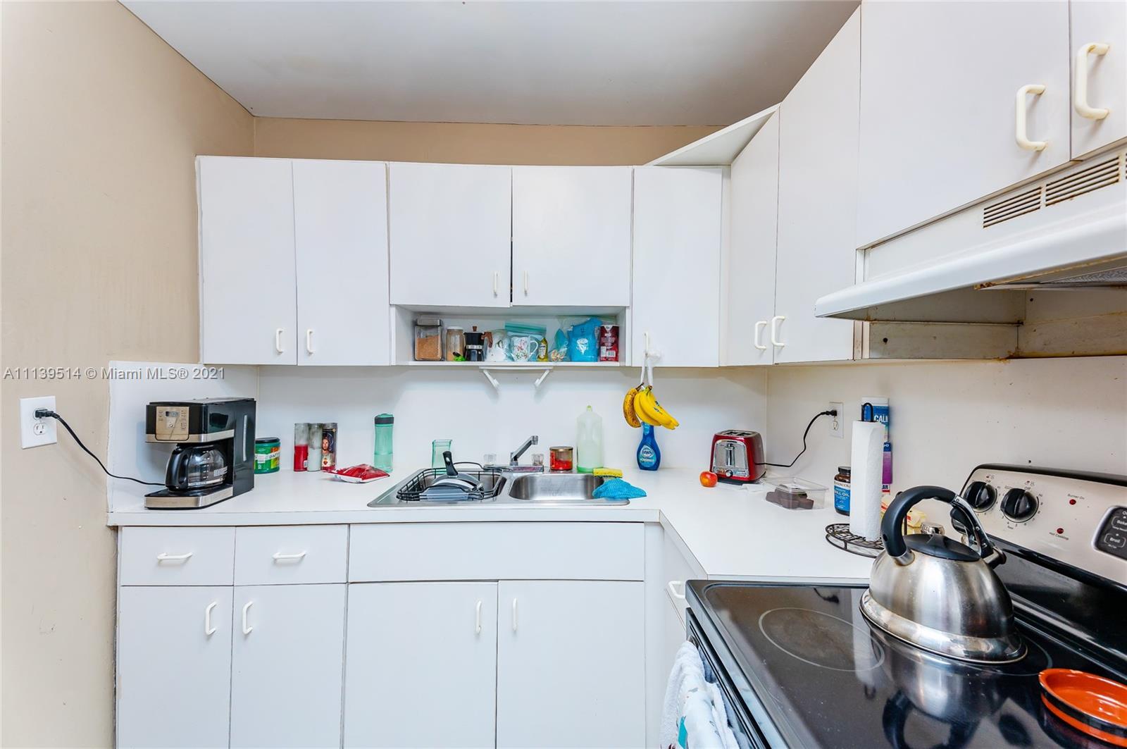 15280 Southwest 80th Street, Unit 11 Miami, FL 33193 - Photo 4 of 13 a kitchen with white cabinets and a sink