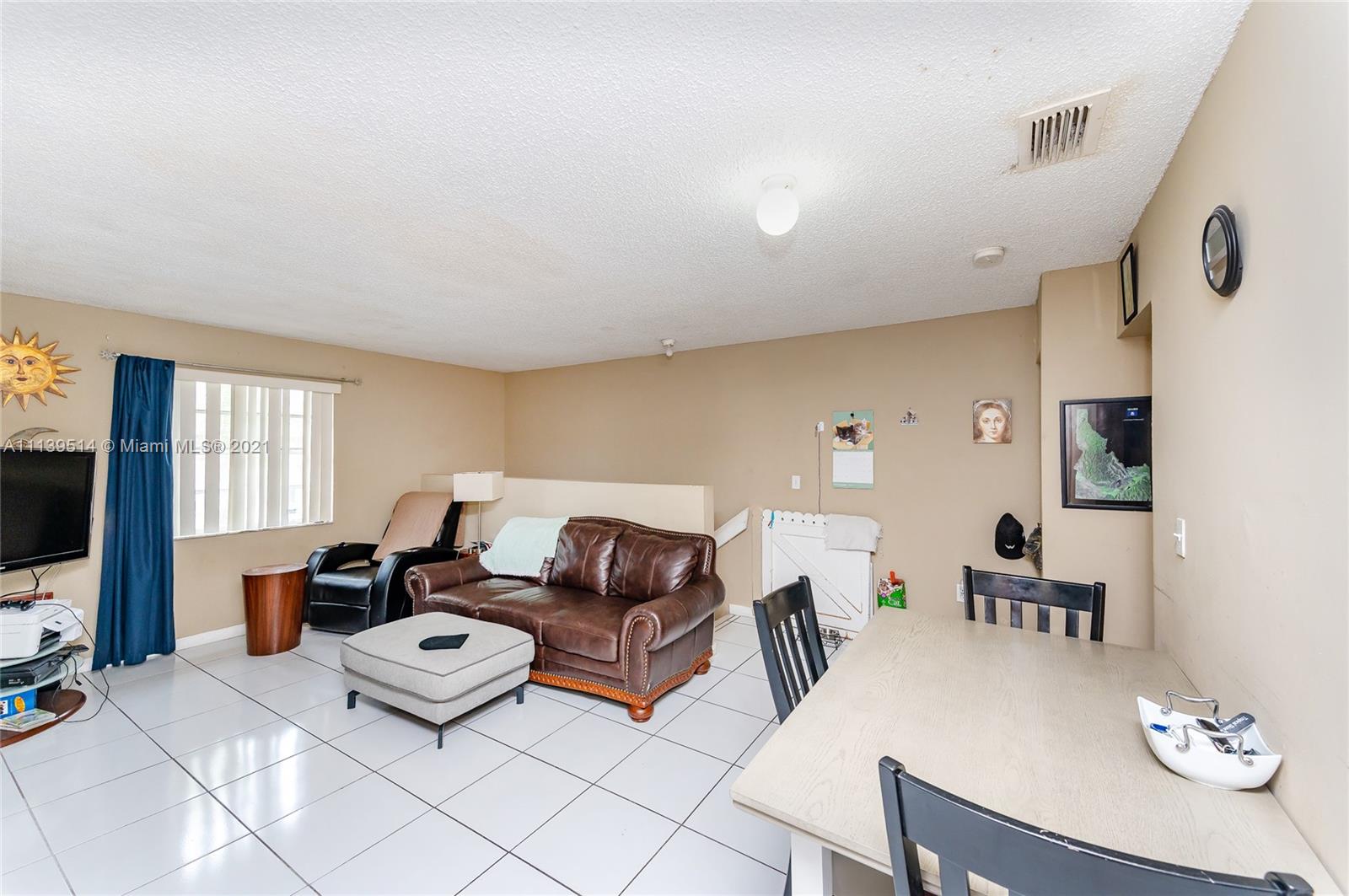 15280 Southwest 80th Street, Unit 11 Miami, FL 33193 - Photo 5 of 13 a living room with furniture a flat screen tv and a window