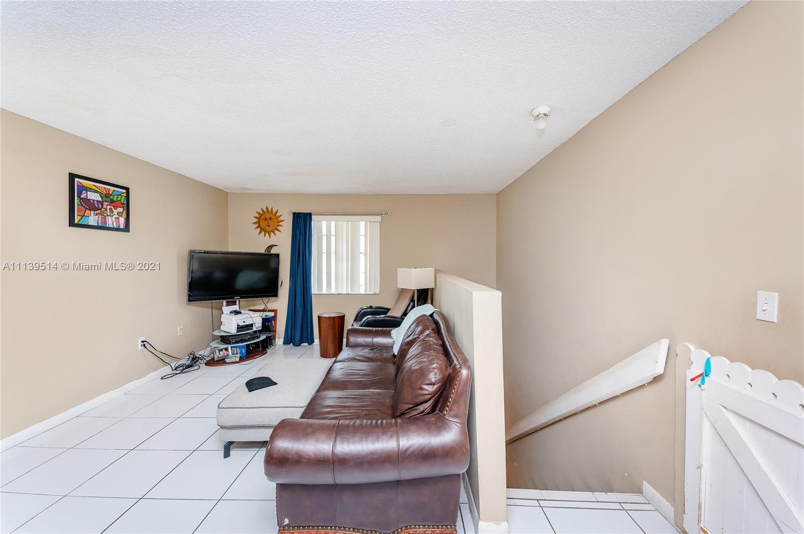 15280 Southwest 80th Street, Unit 11 Miami, FL 33193 - Photo 7 of 13 a living room with furniture and a flat screen tv
