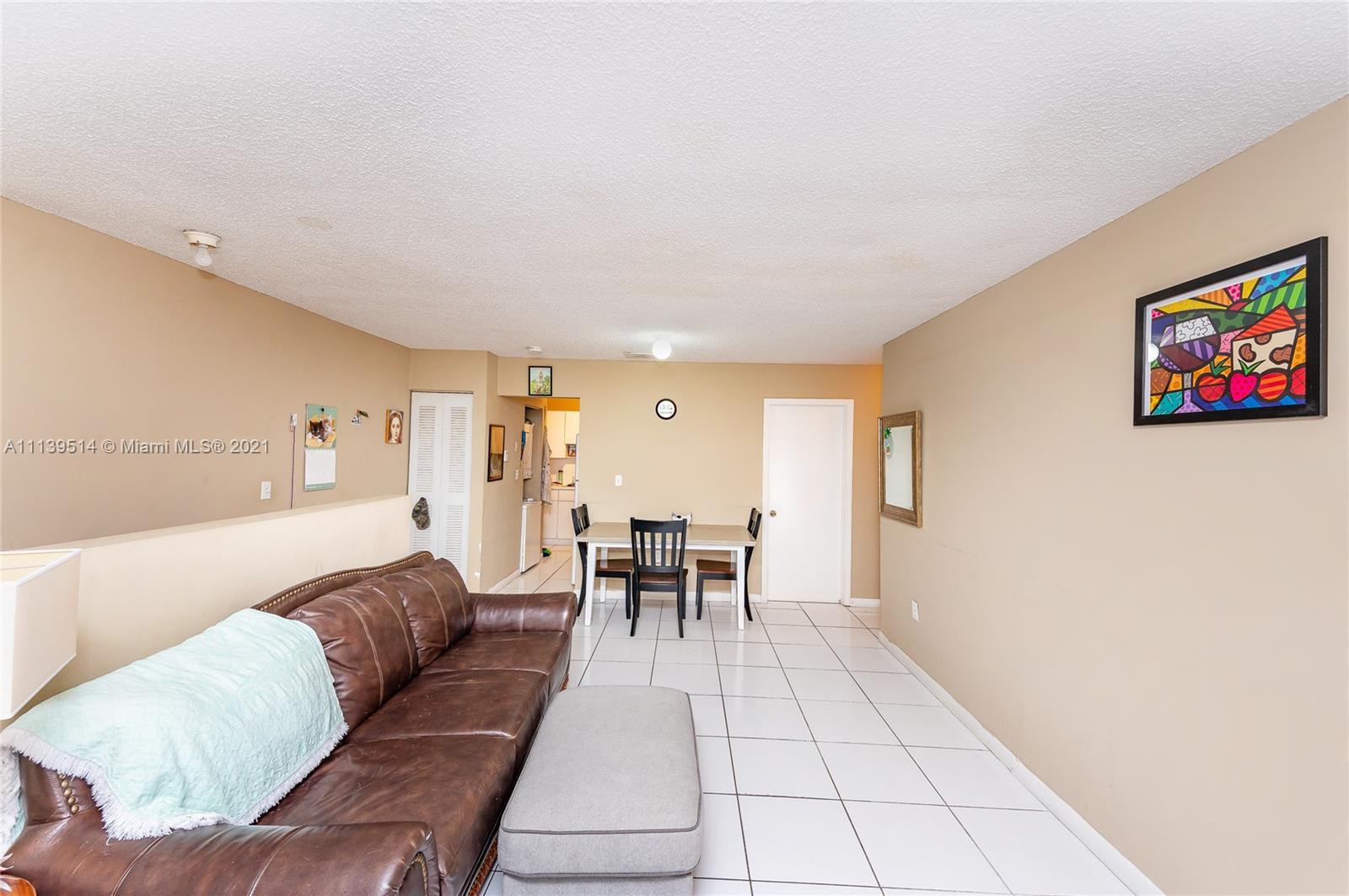 15280 Southwest 80th Street, Unit 11 Miami, FL 33193 - Photo 8 of 13 a living room with furniture and a dining table